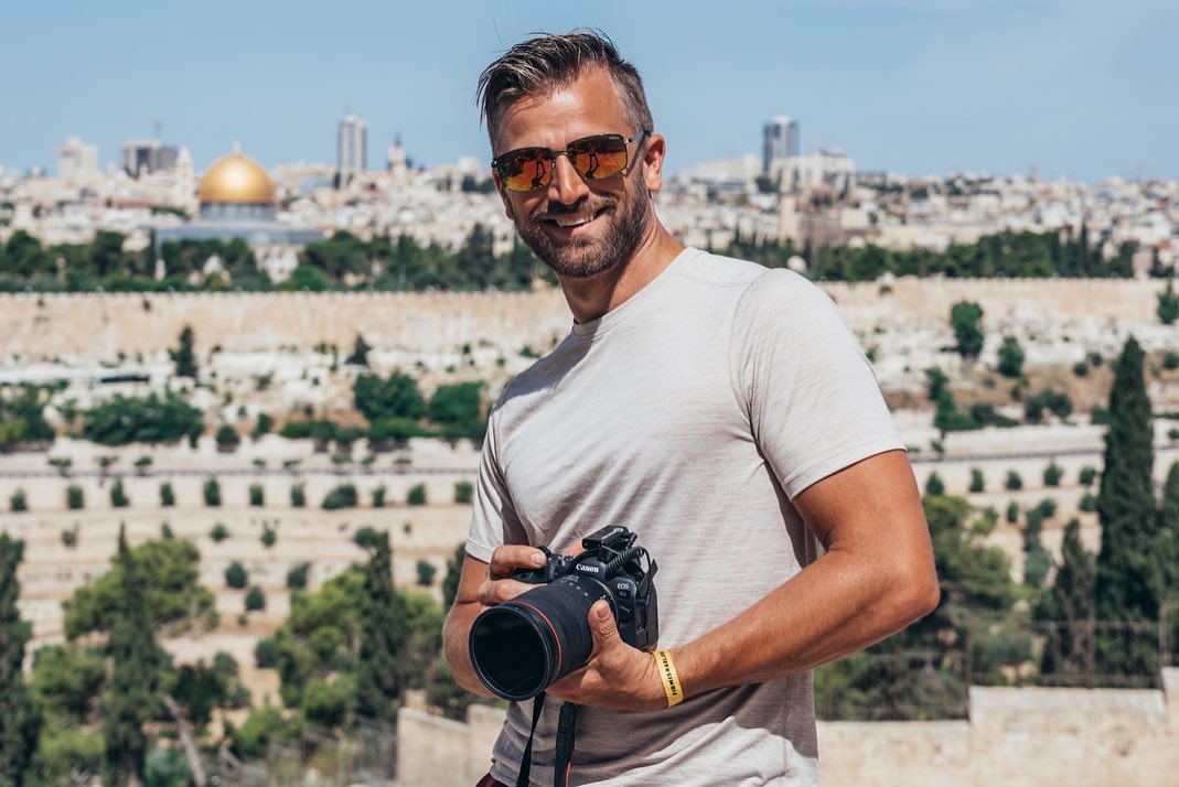 Samuel Rader holding a camera outdoors in Jerusalem